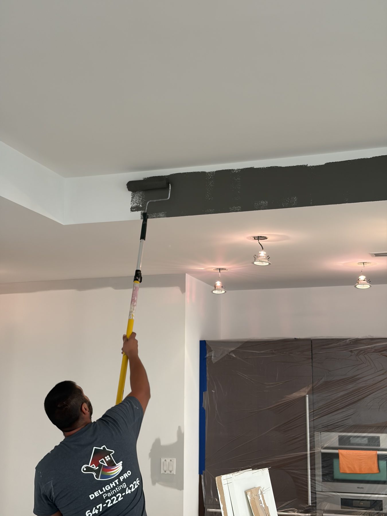 Painter rolling a ceiling bulkhead