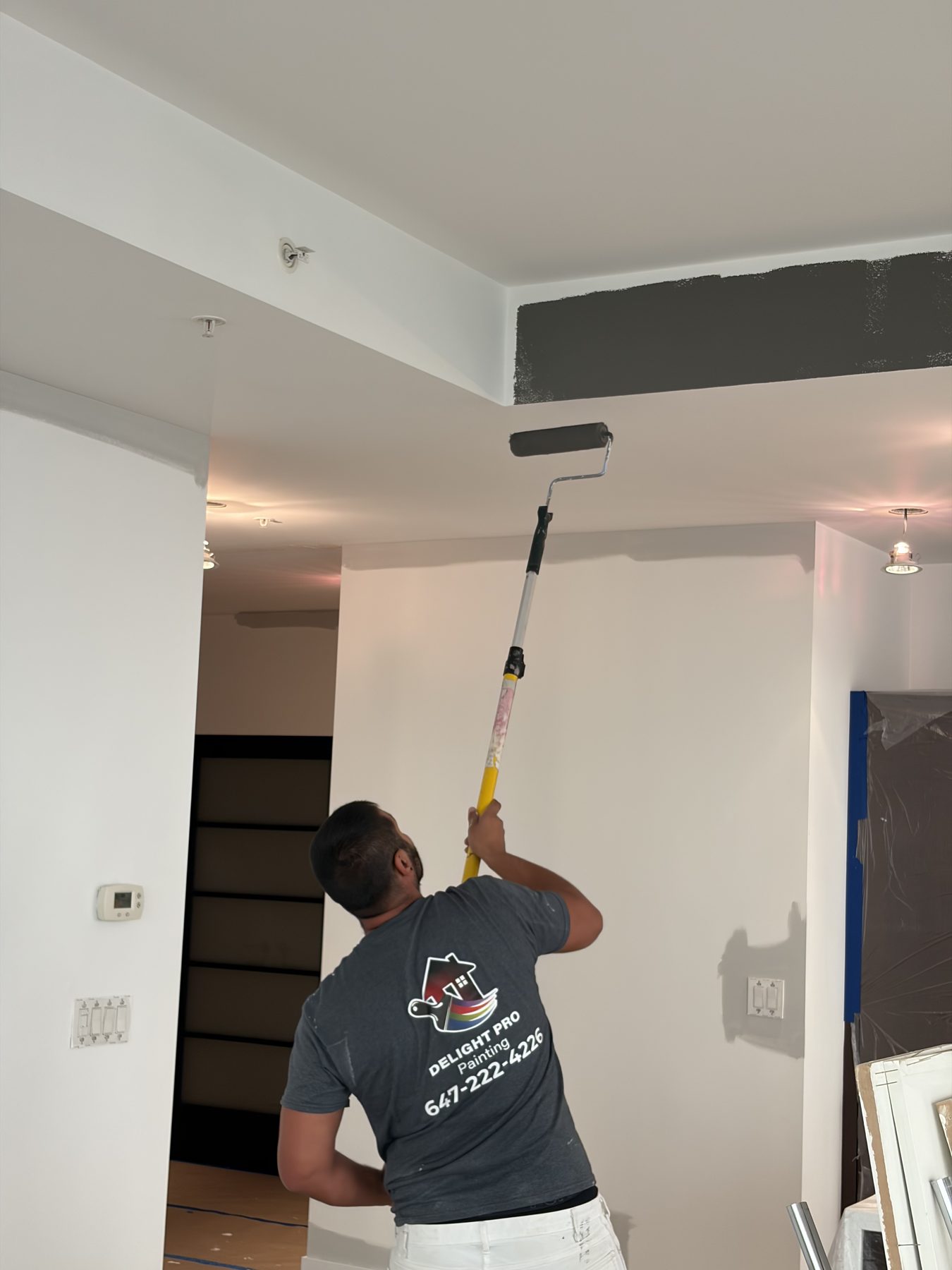 Painter finishing a ceiling in the living area
