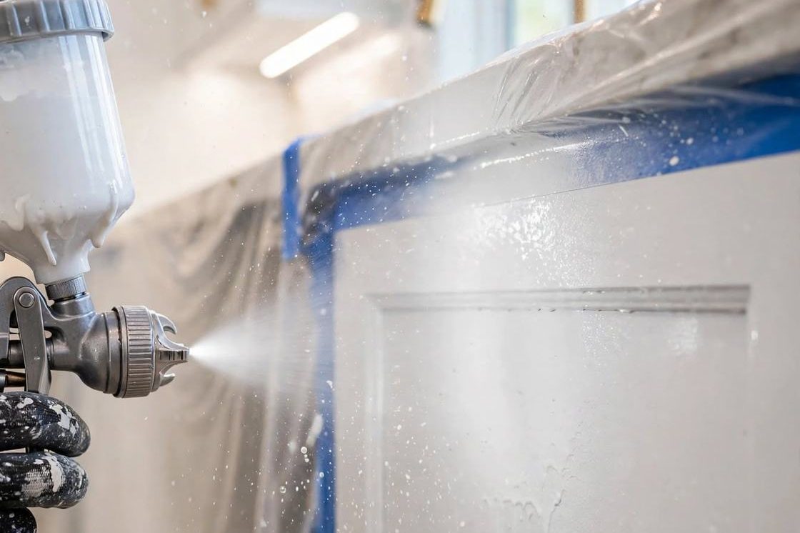 Spray gun finishing a cabinet door